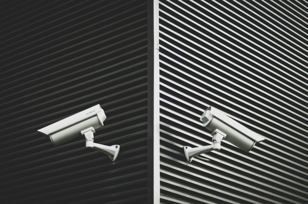 Two grey CCTV cameras, representing consistent camera systems across several business premises