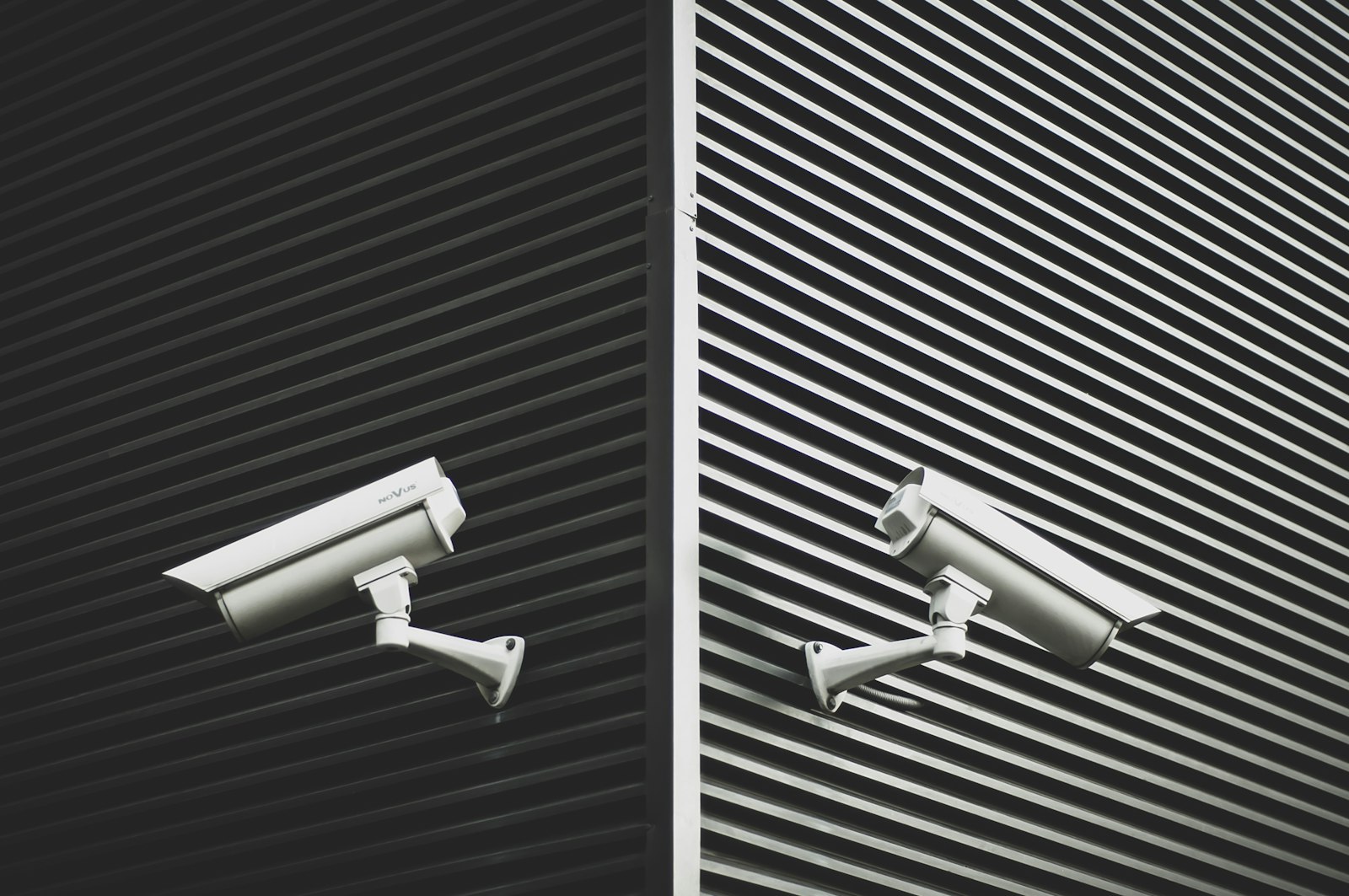 Two grey CCTV cameras, representing consistent camera systems across several business premises