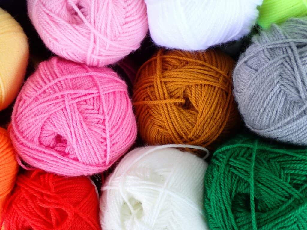 Pile of balls of yarn sitting next to each other, relevant to knitting tips and hacks