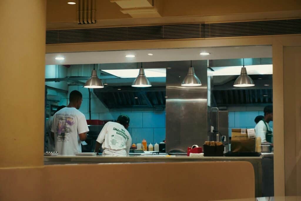 People working in a commercial kitchen, relevant to organising a busy professional food preparation space